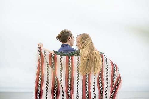 grand haven woman holding red and black aztec textile blonde
